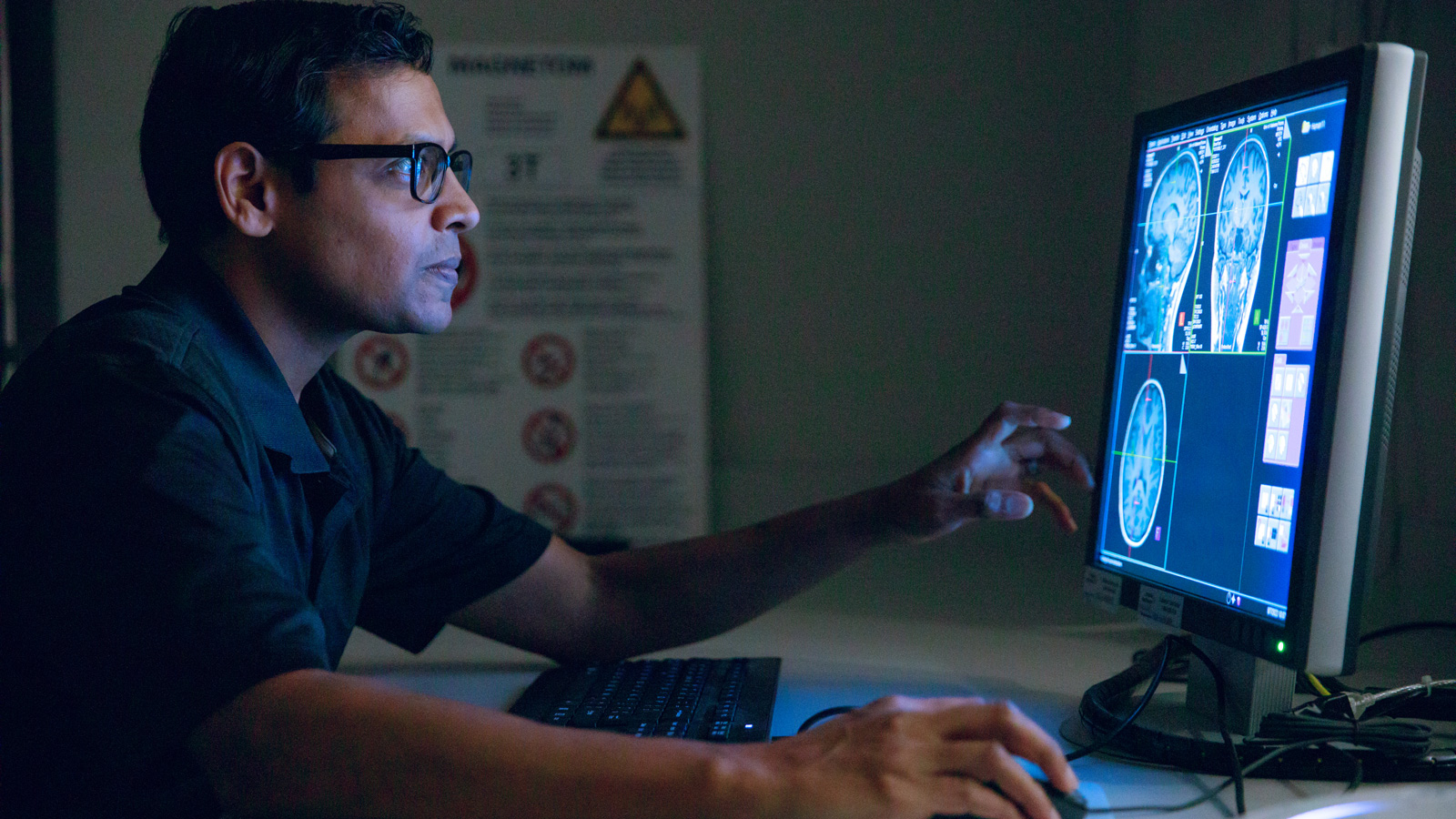 Researcher in the MRI Facility studying scans of a brain